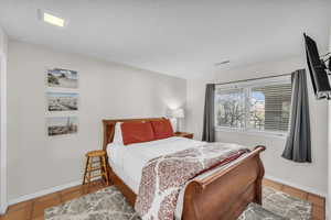 Bedroom featuring tile patterned floors and a textured ceiling