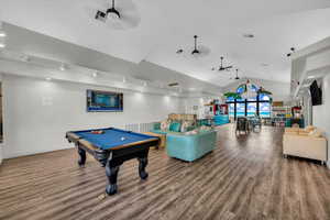 Game room featuring ceiling fan, billiards, hardwood / wood-style floors, and lofted ceiling