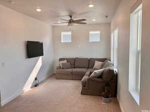 Carpeted living room with a textured ceiling and ceiling fan