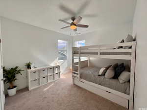 Carpeted bedroom featuring a textured ceiling and ceiling fan