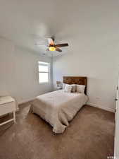 Carpeted bedroom with a textured ceiling and ceiling fan