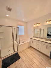 Bathroom featuring vanity, a textured ceiling, and plus walk in shower