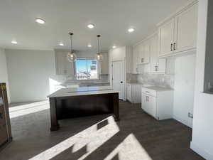 Kitchen featuring pendant lighting, white cabinetry, and a kitchen island