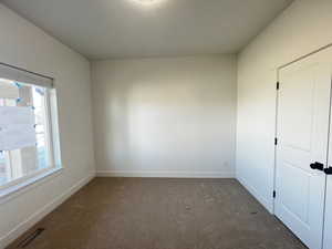 Empty room with a healthy amount of sunlight and dark carpet