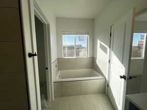 Bathroom featuring tile patterned floors and tiled tub