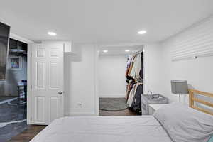 Bedroom with dark hardwood / wood-style floors and a closet