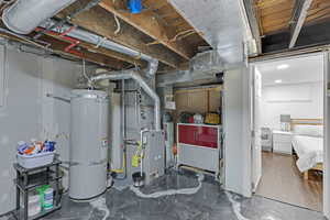 Utility room featuring strapped water heater and heating unit