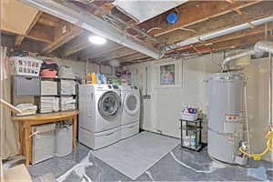 Washroom with strapped water heater and washing machine and clothes dryer