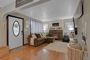 Living room with light hardwood / wood-style floors and a brick fireplace