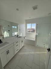 Bathroom featuring tile patterned floors, vanity, and shower with separate bathtub