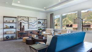 Carpeted living room with a raised ceiling