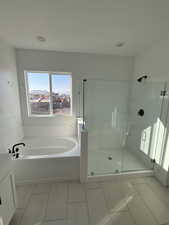 Bathroom featuring vanity and separate shower and tub