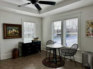 Dining space with ceiling fan and a raised ceiling