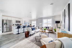 Living room with light hardwood / wood-style flooring and sink