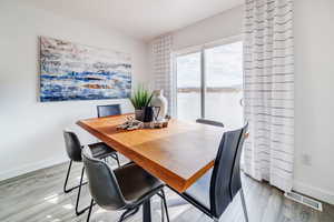 Dining area with wood-type flooring and a water view