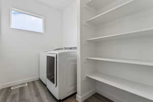 Laundry area featuring washer and clothes dryer and dark hardwood / wood-style floors