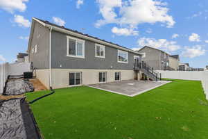 Rear view of house featuring cooling unit, a patio area, and a lawn