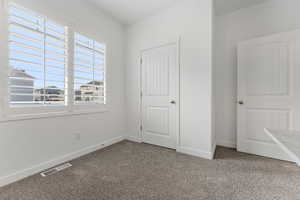 Unfurnished bedroom with carpet flooring and a closet