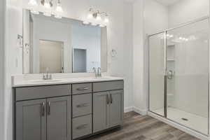 Bathroom with a shower with door, vanity, and wood-type flooring