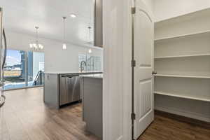 Kitchen featuring dishwasher, decorative light fixtures, a textured ceiling, a notable chandelier, and dark hardwood / wood-style flooring