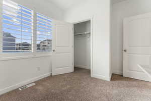 Unfurnished bedroom with carpet flooring and a closet