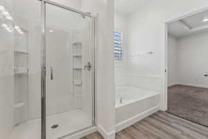 Bathroom featuring hardwood / wood-style flooring and independent shower and bath