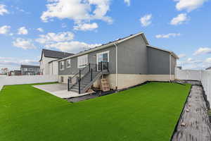 Rear view of house featuring a patio area and a yard