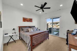 Carpeted bedroom featuring ceiling fan and access to exterior