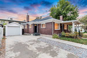 View of front of home with a garage and an outdoor structure