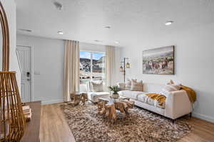 Living room with a textured ceiling and light wood-type flooring