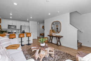 Living room with sink, a textured ceiling, and light hardwood / wood-style flooring