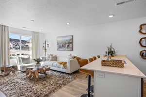 Living room featuring a textured ceiling and light wood-type flooring