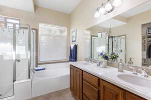 Bathroom featuring vanity, shower with separate bathtub, tile patterned flooring, and a chandelier