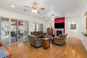 Living room featuring ceiling fan and light hardwood / wood-style floors