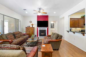 Living room featuring ceiling fan and light hardwood / wood-style flooring