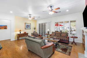 Living room featuring ceiling fan and light hardwood / wood-style floors