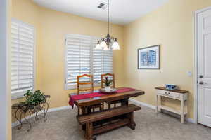 Tiled dining area featuring a healthy amount of sunlight and a chandelier