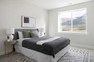 Carpeted bedroom featuring multiple windows and a mountain view