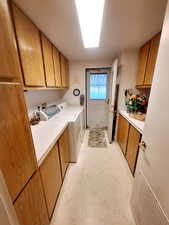 Clothes washing area with cabinets and washer and clothes dryer