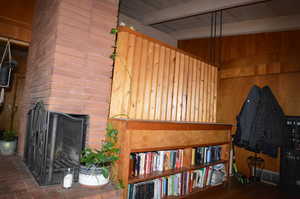 Room details featuring a fireplace and wood walls