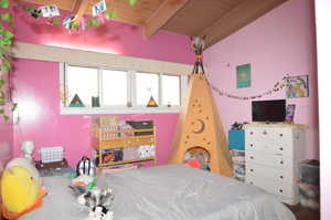 Bedroom featuring wood-type flooring, wood ceiling, multiple windows, and beamed ceiling