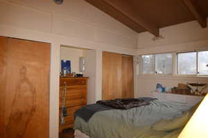 Bedroom with lofted ceiling with beams and wood ceiling