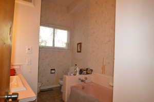 Bathroom featuring toilet, tile patterned flooring, a tub to relax in, and vanity