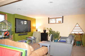 Living room with a textured ceiling and carpet flooring