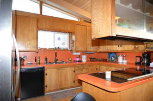 Kitchen with sink, lofted ceiling, and black appliances