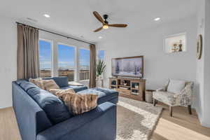 Living room featuring ceiling fan and light hardwood / wood-style flooring