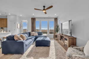 Living room featuring ceiling fan and light hardwood / wood-style floors