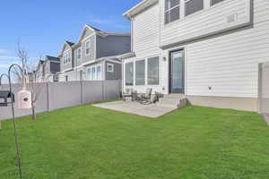 Rear view of property with a yard and a patio area