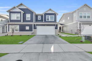 View of front facade featuring a front yard and a garage