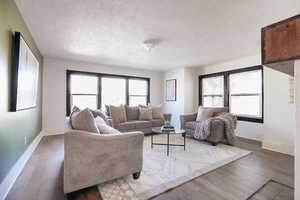 Living room with a textured ceiling and hardwood / wood-style flooring